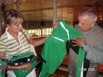  Vlasta Švikruhová  a Cyril Mečiar pozerajú logo darcu športových súprav pre zápasníkov Baníka Prievidza. 